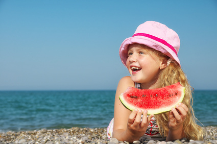 Happy child on the sea with watermelon